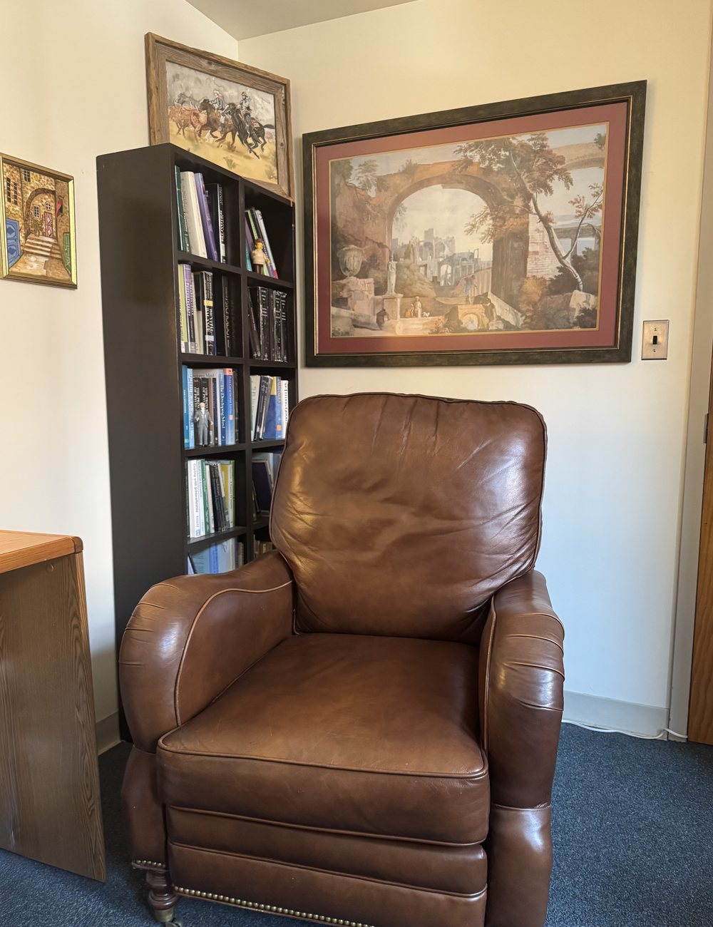 A leather armchair beside a bookcase in Dr. Morehead&rsquo;s office