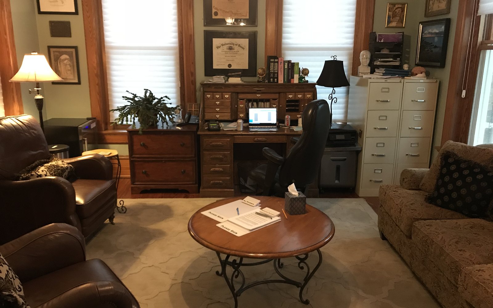Dr. Morehead&rsquo;s consulting room: armchairs, a low table, a desk and bookshelves